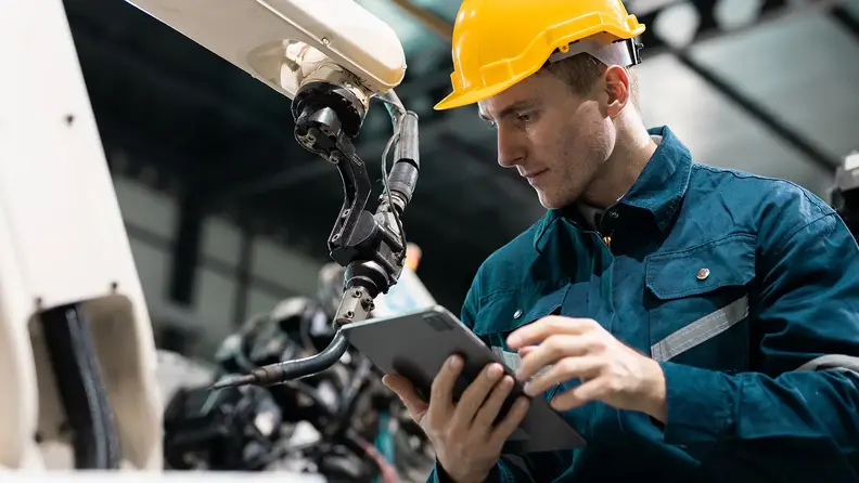 Ingeniero industrial revisando maquinaria con mantenimiento del sistema ANAC de TotalEnergies.
