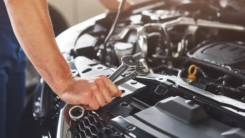 Técnicos automotrices inspeccionando motor de vehículo.