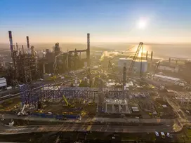 le soleil se lève derrière la raffinerie et l'unité HDT VGO en construction