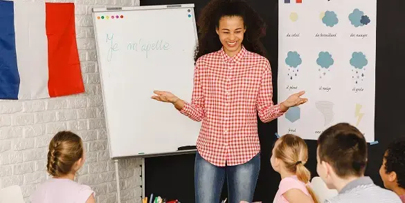 Teacher in classroom with French flag on wall