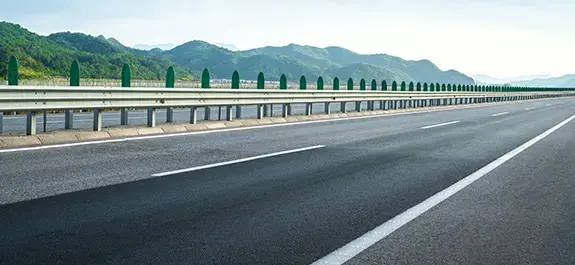 Prázdná dálnice vedoucí zelenou kopcovitou krajinou