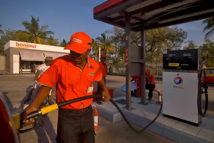 À la station-service Morondava, un pompiste fait le plein de la voiture d'un client.