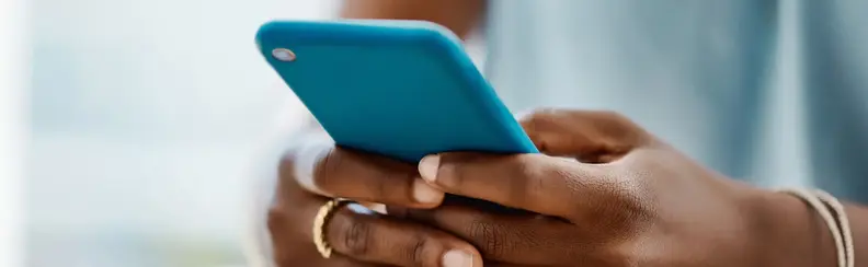 An image of a person looking and using a mobile phone.