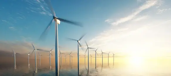Wind turbines in a calm sea with the horizon in the background