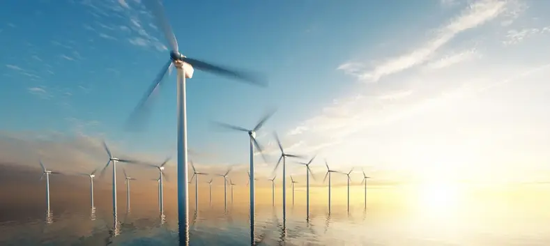 Wind turbines in a calm sea with the horizon in the background