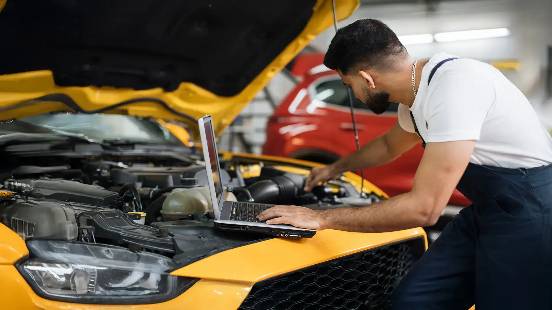 Mecánico realizando afinación de auto y revisión de motor.