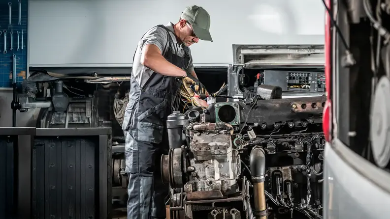 Mecánico realizando mantenimiento de un motor diésel en taller