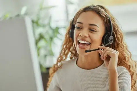 Image of a woman speaking on a headset to a customer.