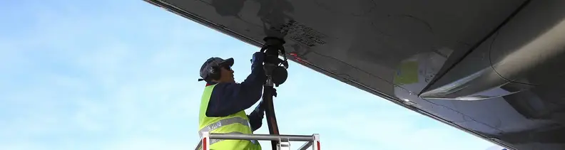 Unterer Teil eines Flugzeugs mit TotalEnergies Tankfahrzeug