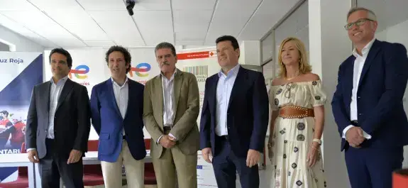 Un grupo de seis personas en traje posan para una foto en una oficina de TotalEnergies