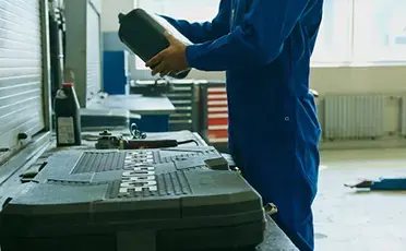 mechanic holding a bottle of engine oil