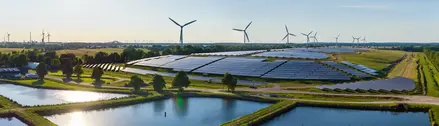 A panoramic image of a windfarm and solarfarm working together.