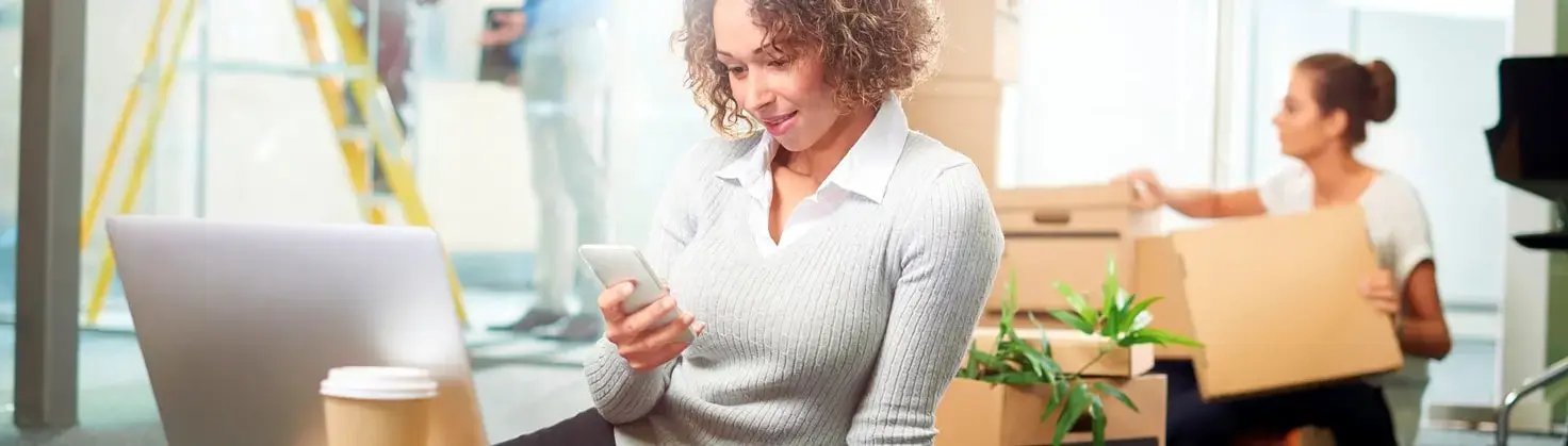 Woman looking on her mobile for assistance in moving premises