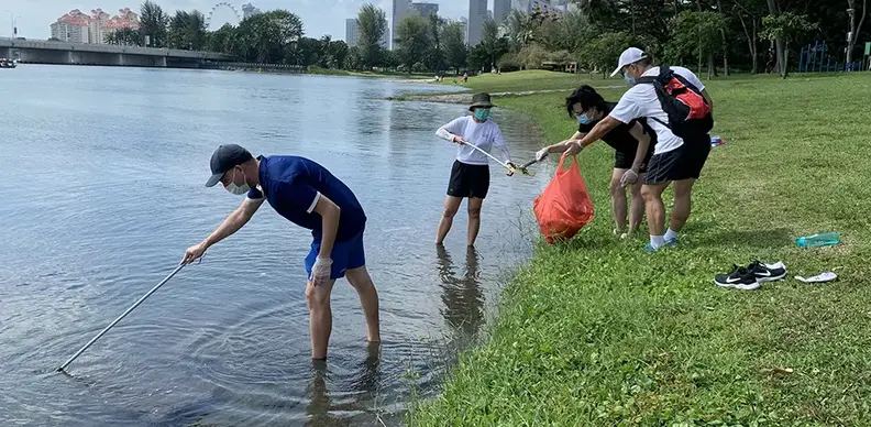 employees picking up litter along Marina Reservoir