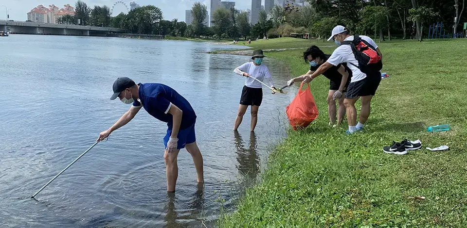 employees picking up litter along Marina Reservoir