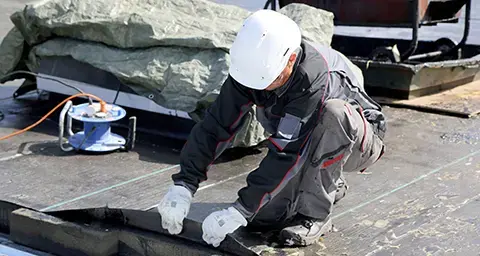 Arbeiter, der ein Dach abdichtet