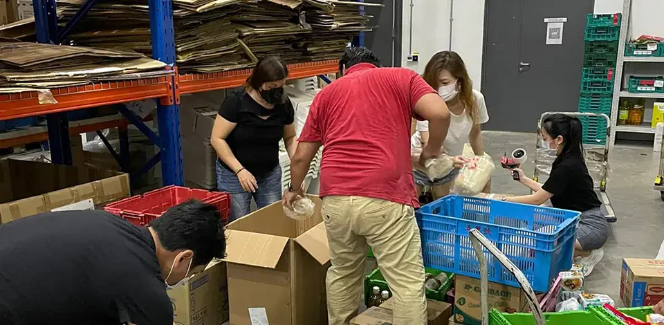 employees sorting out canned food at FoodBank warehouse