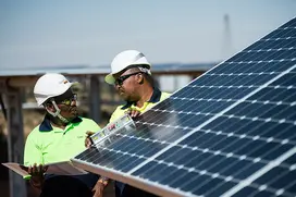 Operators checking solar panels installed at the TotalEnergies​ Sunpower solar power plant in Prieska.