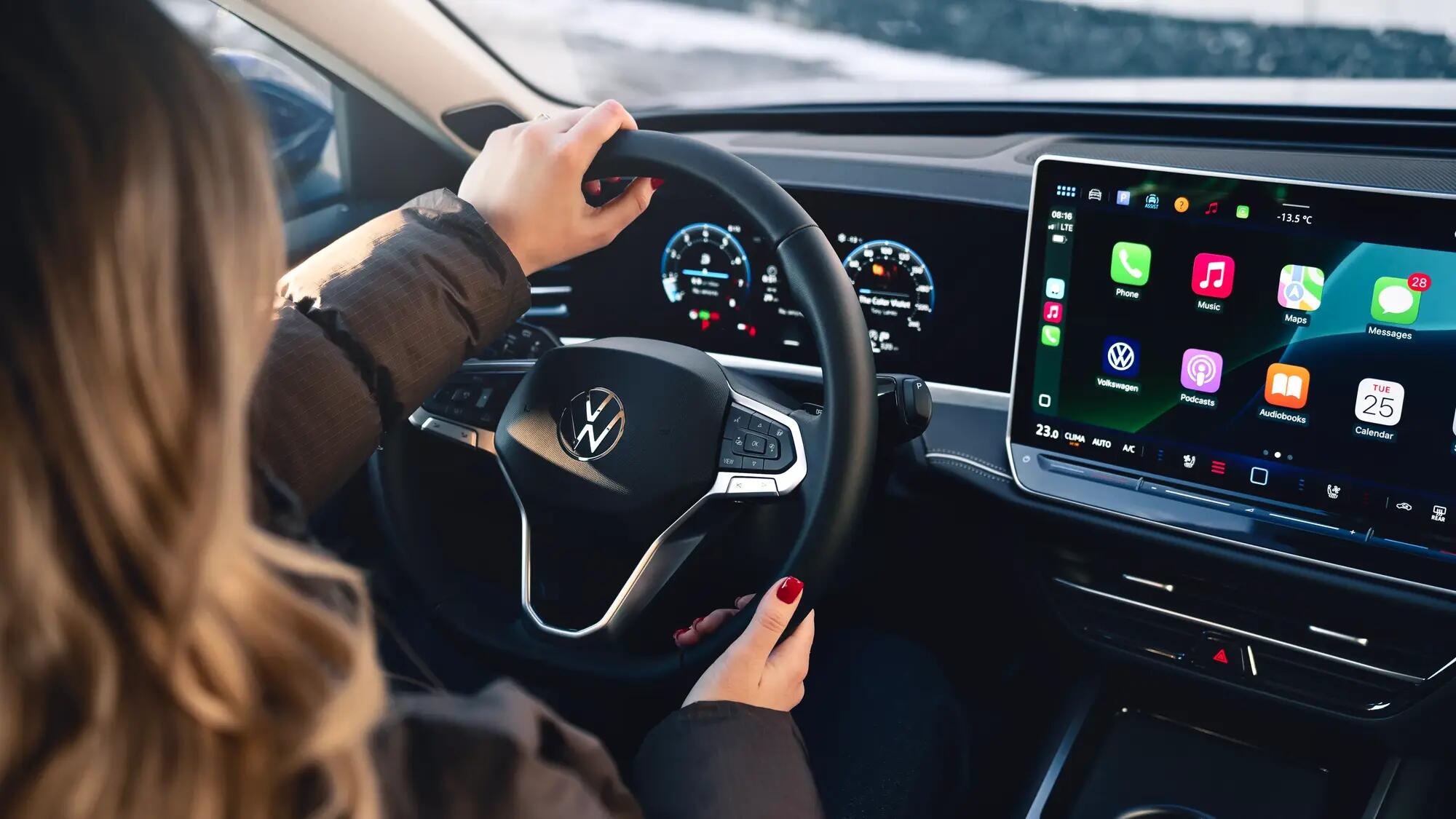 woman behind a steering wheel of a Volkswagen with a visible screen display