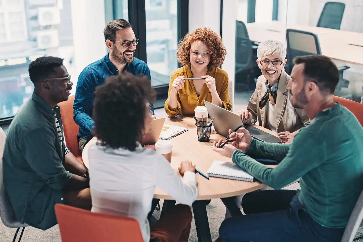 An image showing a team working together around a table.