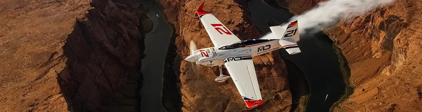 Vogelperspektive eines Sportflugzeuges, das über Klippen fliegt