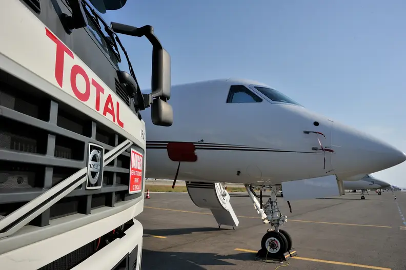 Gros plan sur l'avant d'un camion avitailleur TotalEnergies sur l'aéroport de Nice-Côte d'Azur. A l'arrière plan, un jet.
