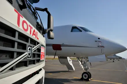 Gros plan sur l'avant d'un camion avitailleur TotalEnergies sur l'aéroport de Nice-Côte d'Azur. A l'arrière plan, un jet.