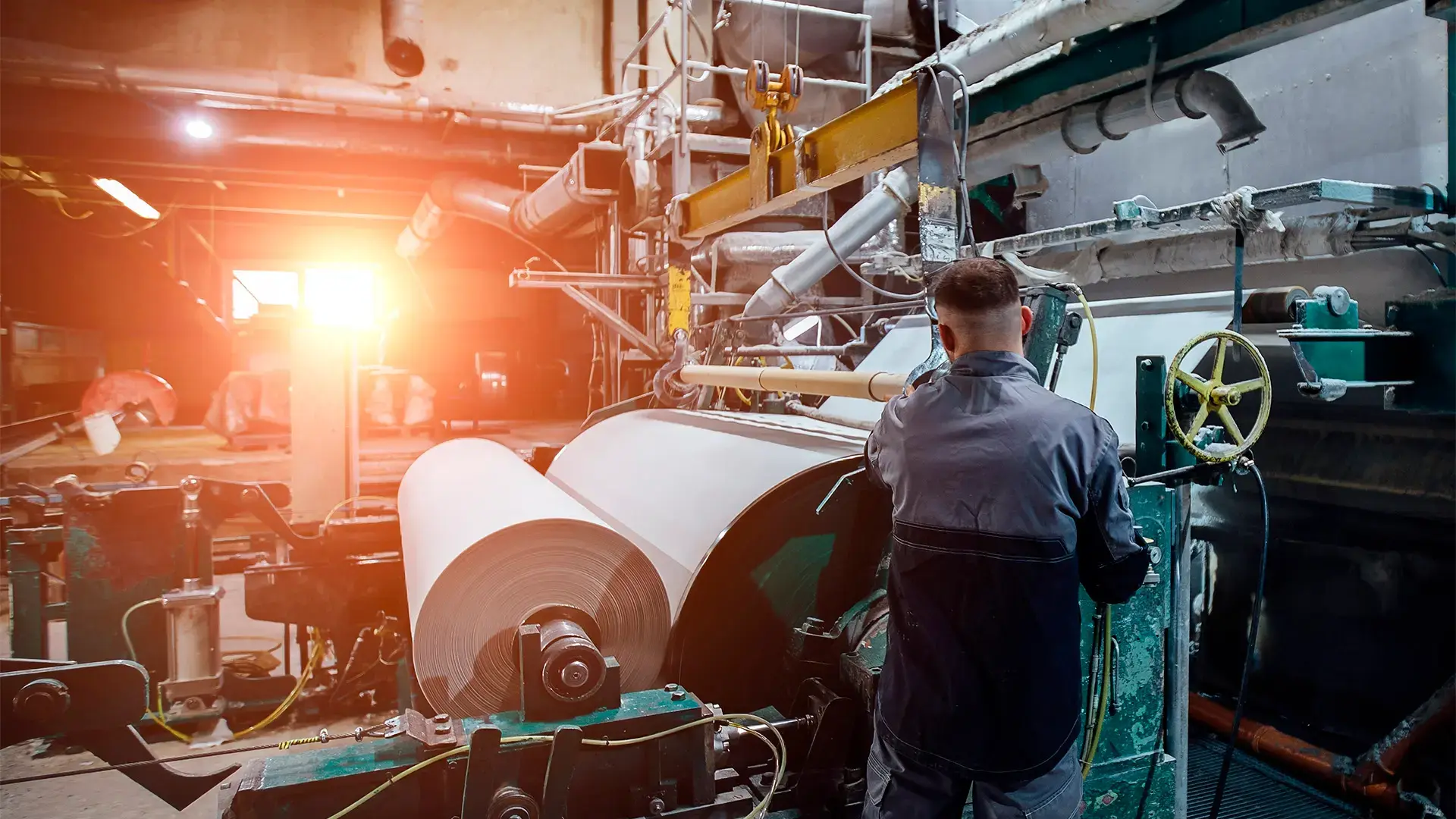 Producción de papel industrial con maquinaria pesada.