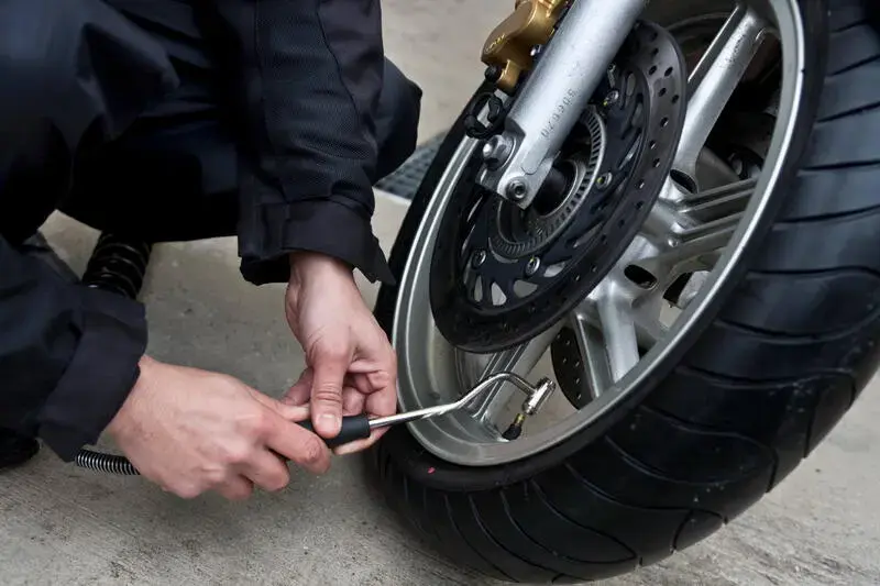 A la station de lavage pour les 2 roues de Saint-Cloud, un client gonfle les pneumatiques de sa moto.