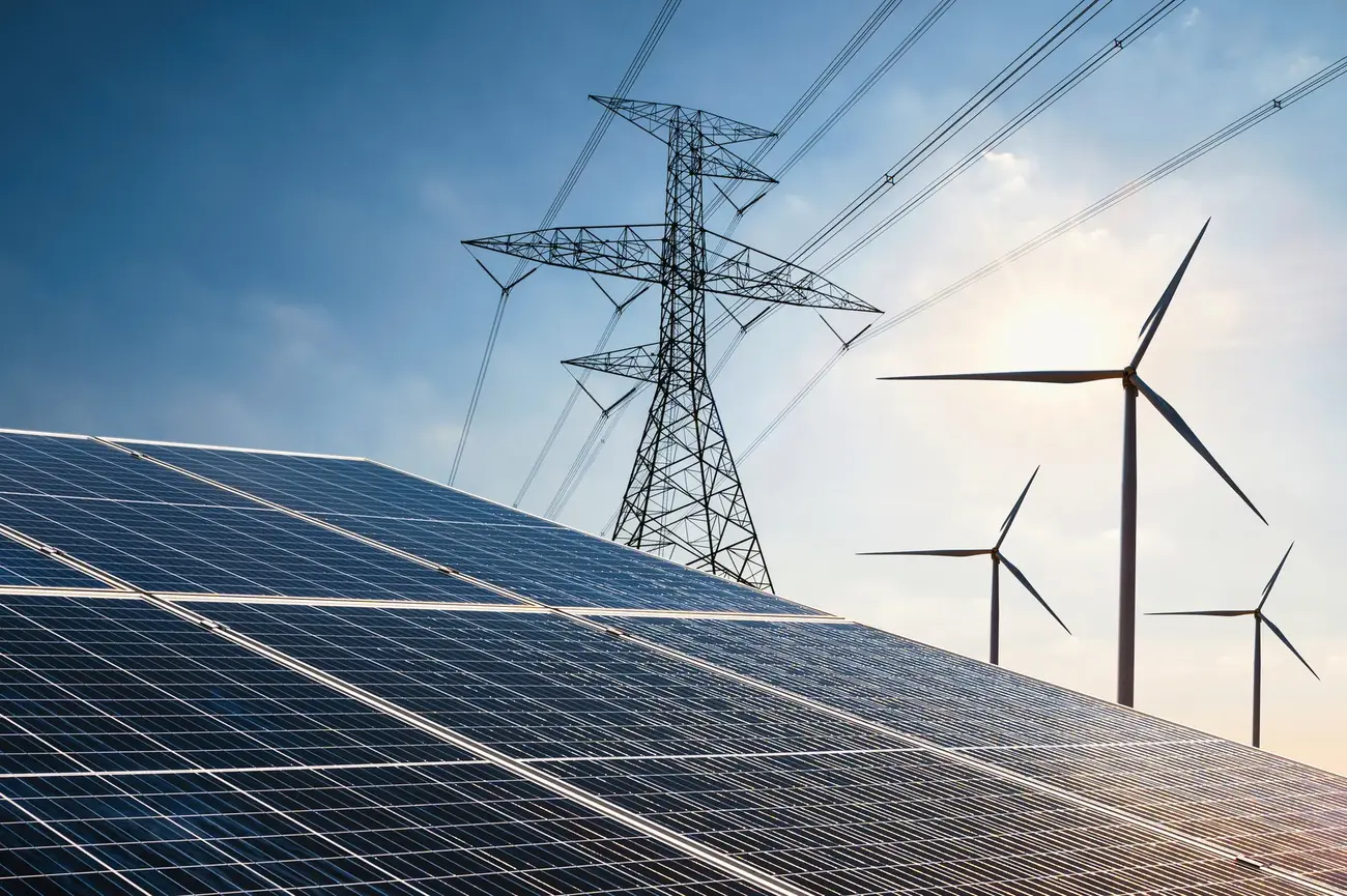 An image of solar panels, wind turbines and electric pylons in one image.