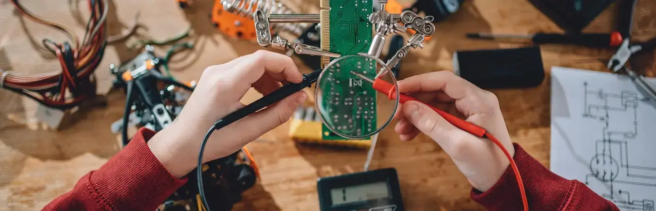 Hands holding equipment to solder pieces of metal together