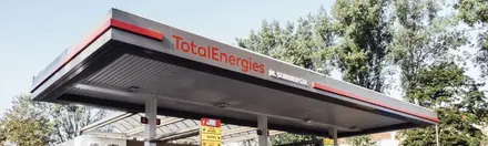 Schrägansicht auf TotalEnergies Tankstelle mit Schriftzug auf dem Dach