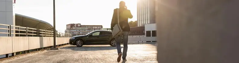 Mann läuft über Parkdeck zu Auto