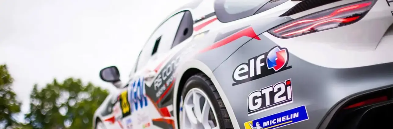 Detail zádě závodního vozu s logy sponzorů včetně značky Elf