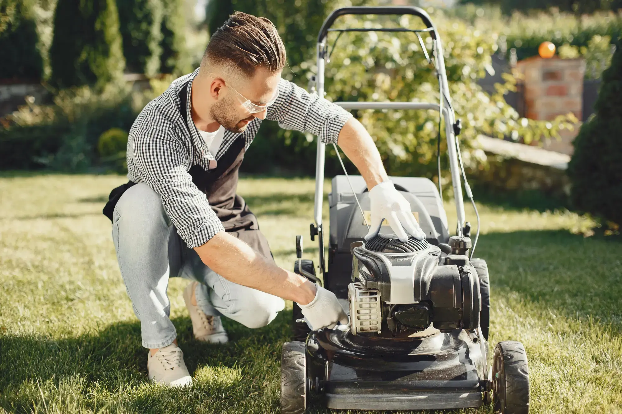 man-cutting-grass-with-lawn-mover-back-yard-male-black-apron-guy-repairs