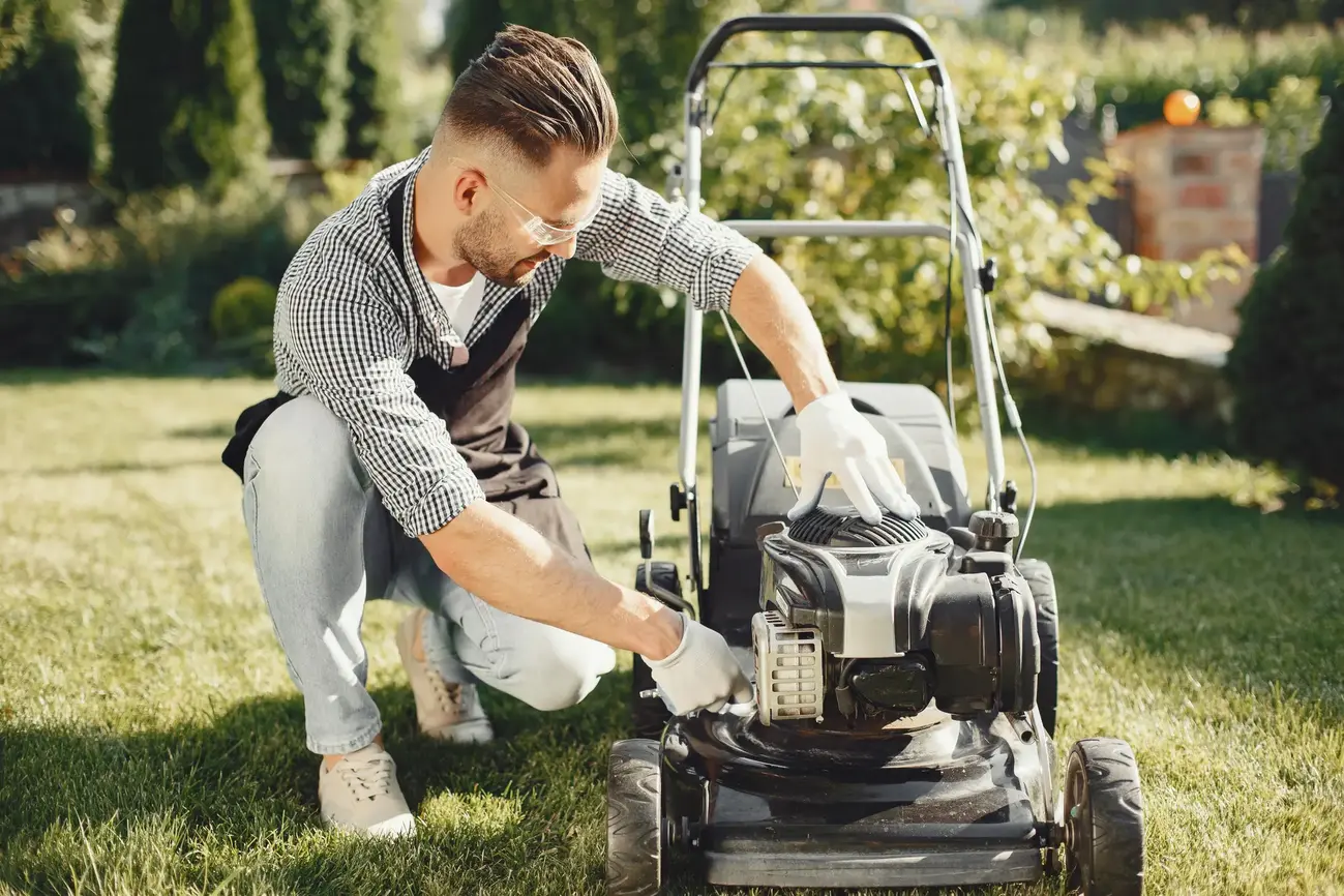 man-cutting-grass-with-lawn-mover-back-yard-male-black-apron-guy-repairs