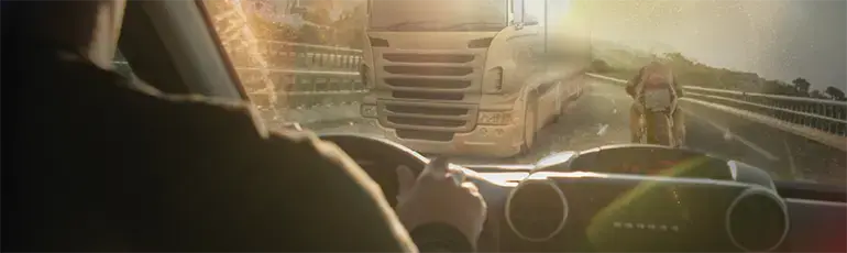 motorcycle and truck on the road from the point of view of inside a car