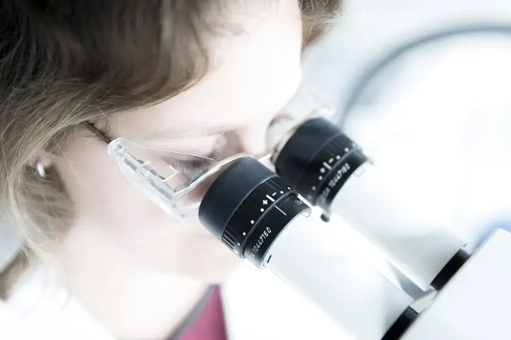 Laborantine regardant dans un microscope