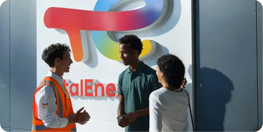 Photo of three people with the TotalEnergies logo