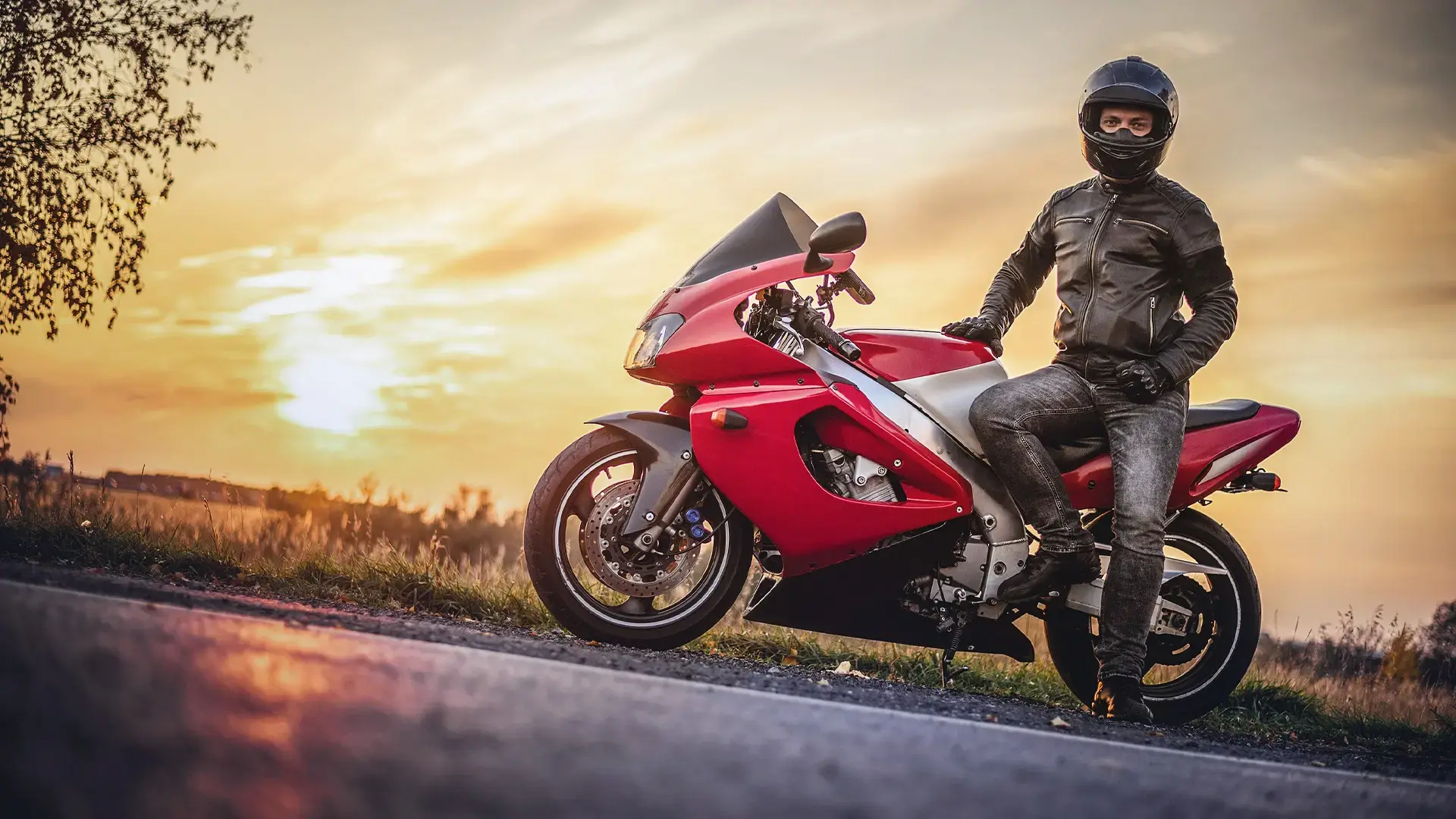 Motociclista con moto deportiva en carretera.