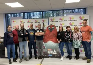 A group of men and women standing and wearing Christmas jumpers