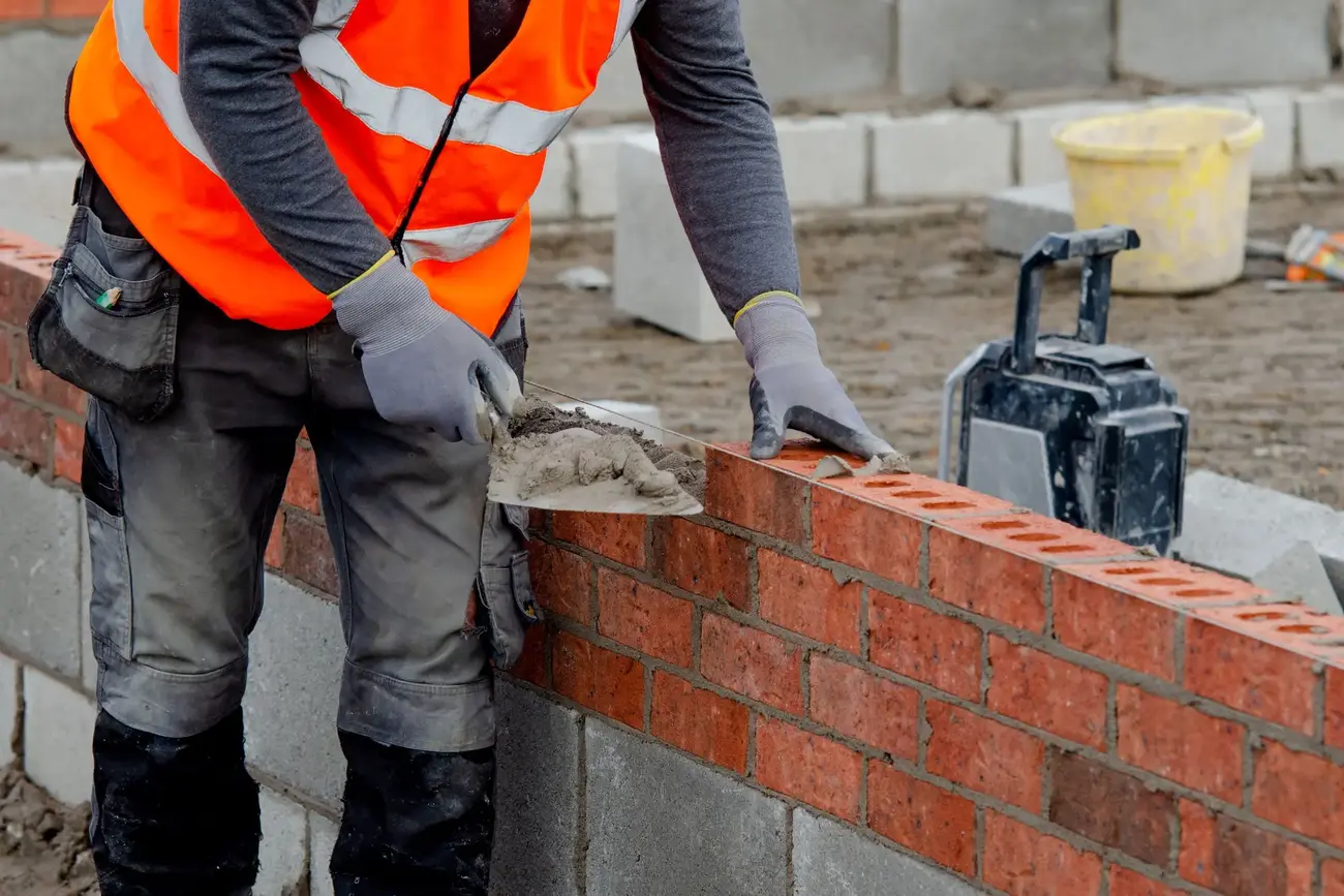 Image of a person laying bricks on a wall