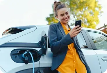 voiture électrique en charge et femme au téléphone
