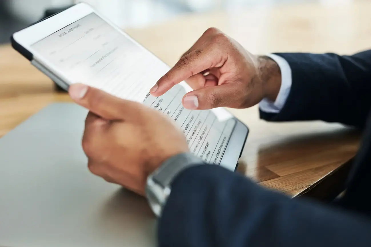 An image showing an individual completing a form using a digital tablet.