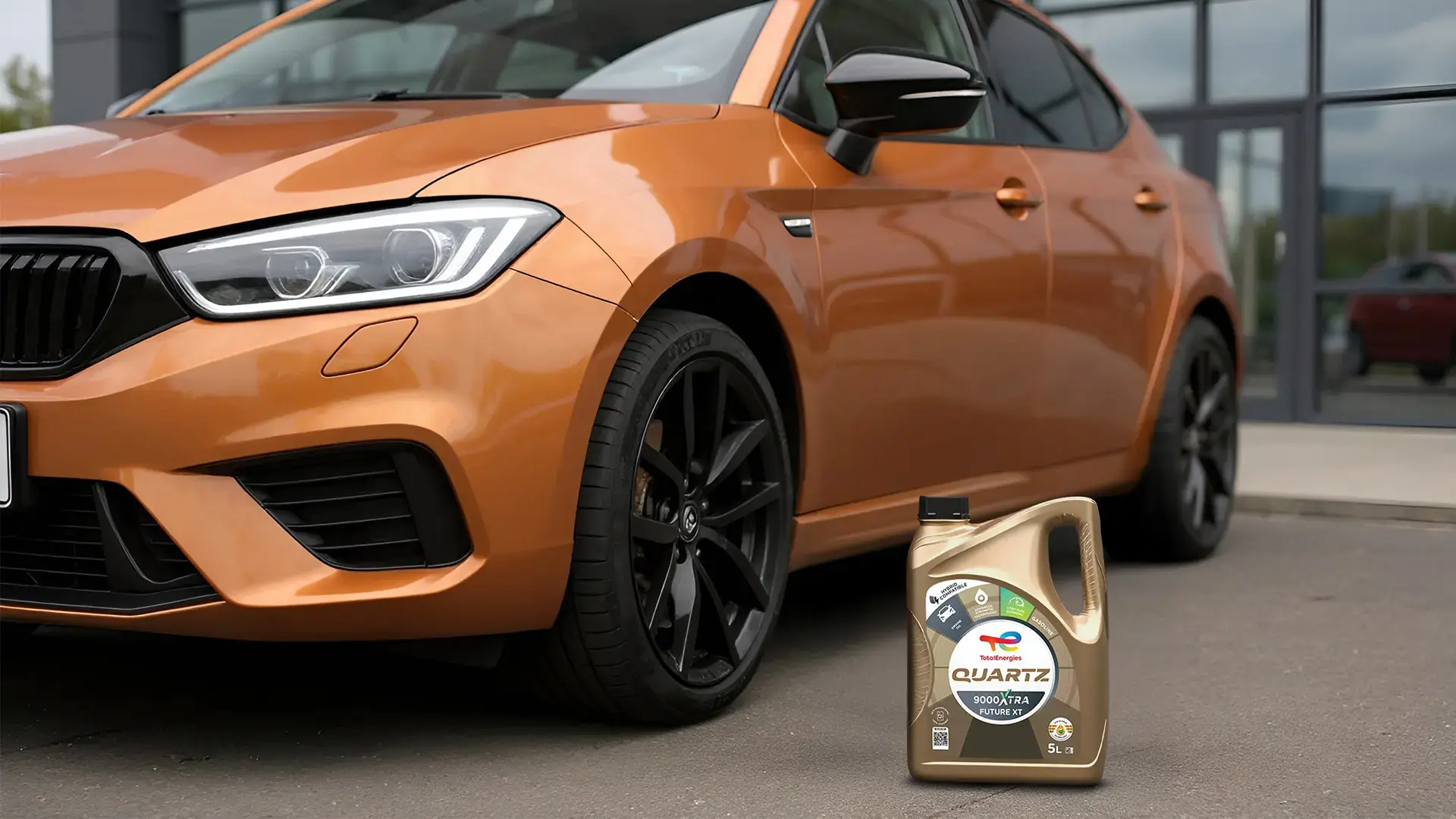 Auto moderno junto a envase de Quartz 9000 Xtra Future XT 0W-20 de TotalEnergies.
