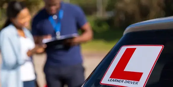 Red L learner plate on back of car