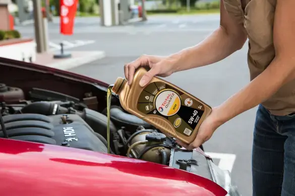 Person pouring Quartz 5w-40 engine oil