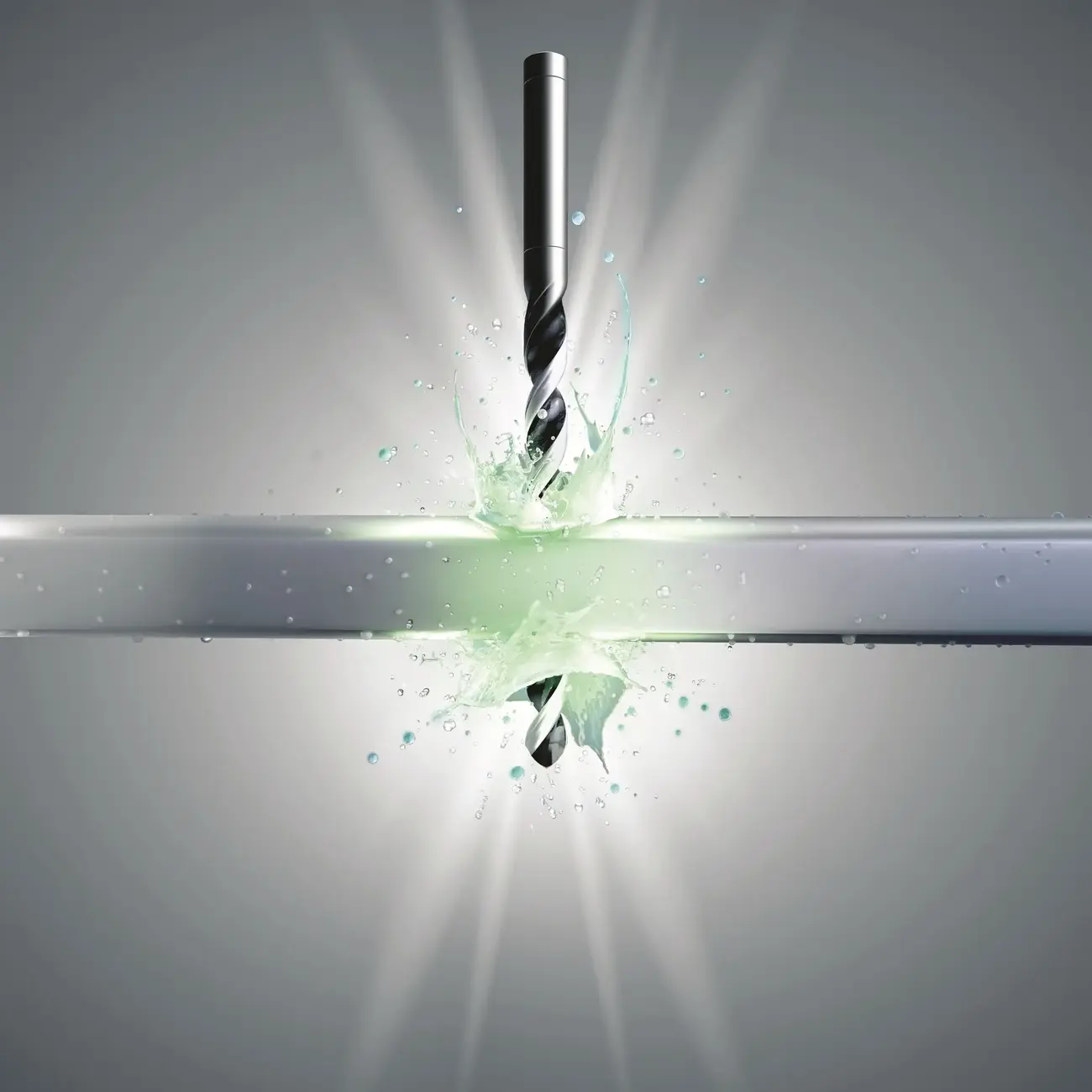 drill bit cutting through metal with cooling fluid splash