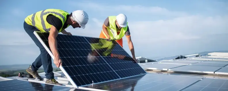 Image of two people installing solar panels.