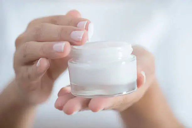 Ruce držící dózu s krémem na ruce